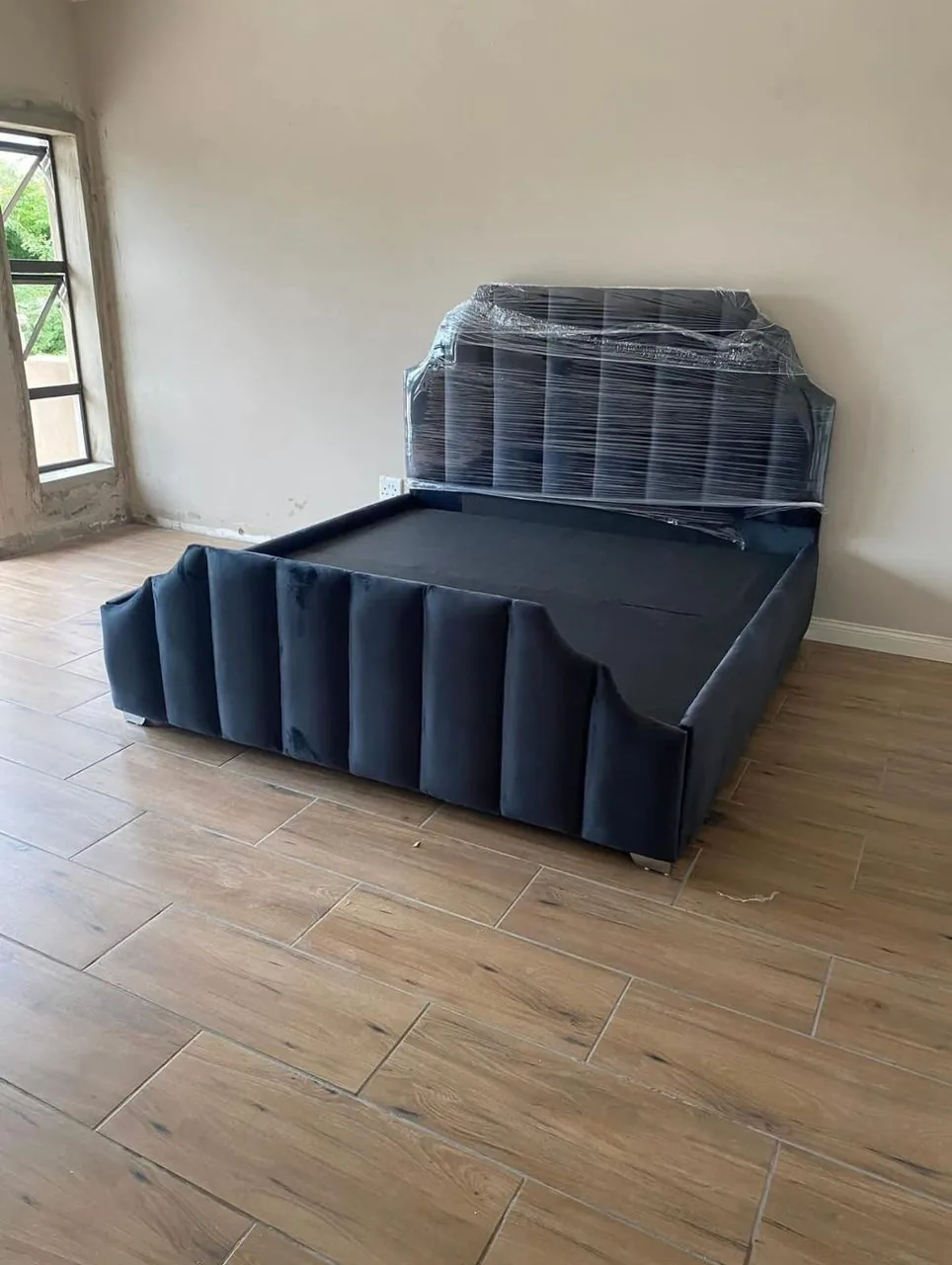 Navy velvet bed set up in a customer's home after delivery
